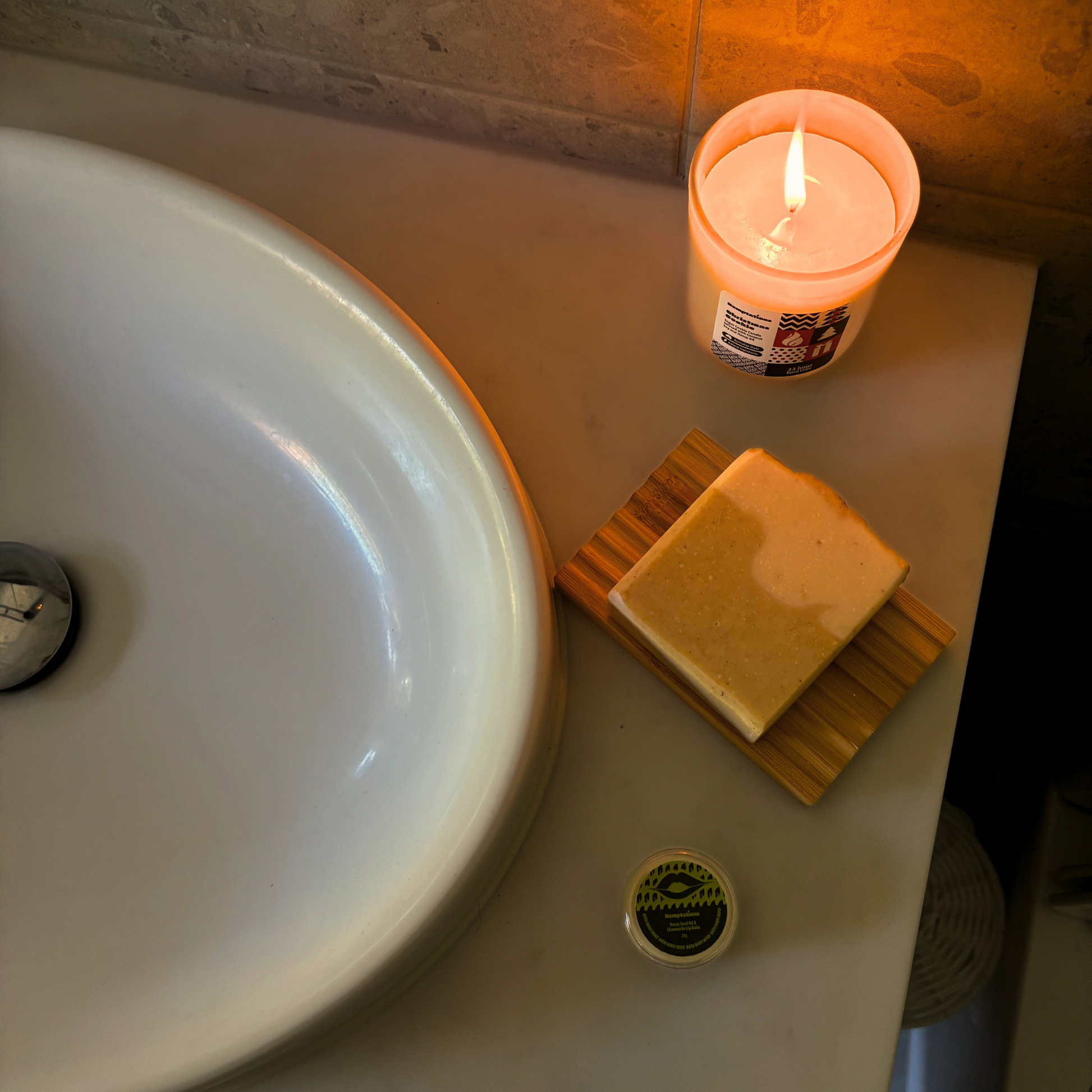 Candle, soap, and soap dish on a bathroom sink