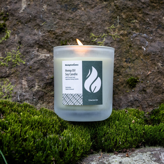 Candle with a label on a stone surface with moss