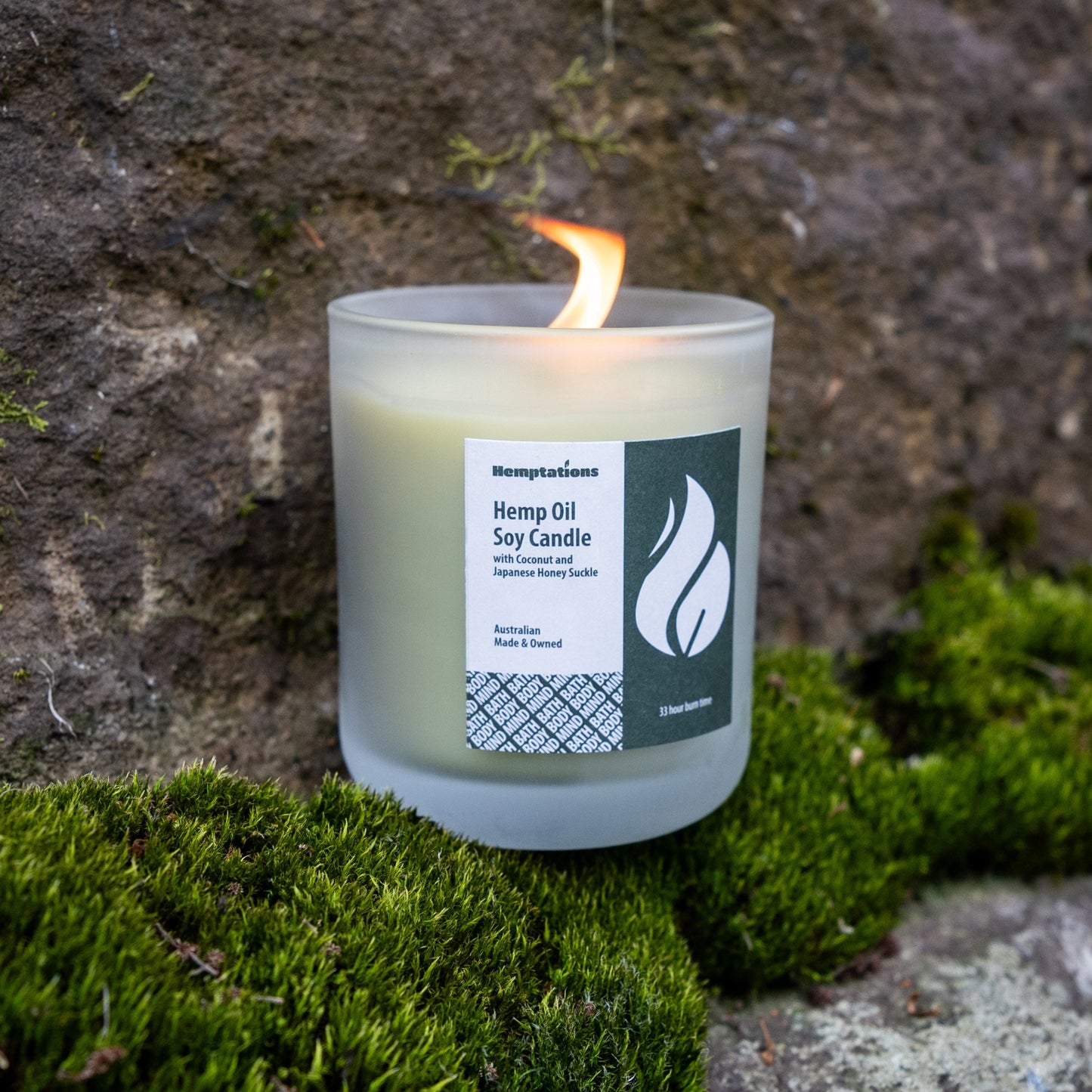 Candle with a label on a stone surface with moss