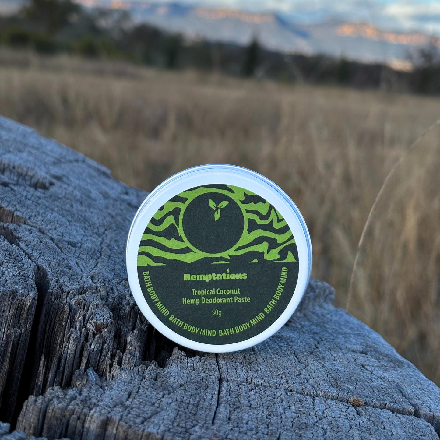 Hemptations tropical coconut hemp deodorant paste container on a wooden surface with a natural background