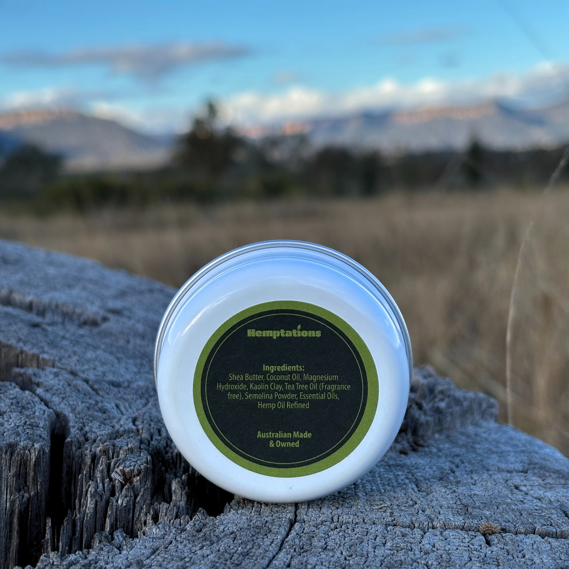 Tin of 'Deodorant' paste on a wooden log with a natural landscape in the background