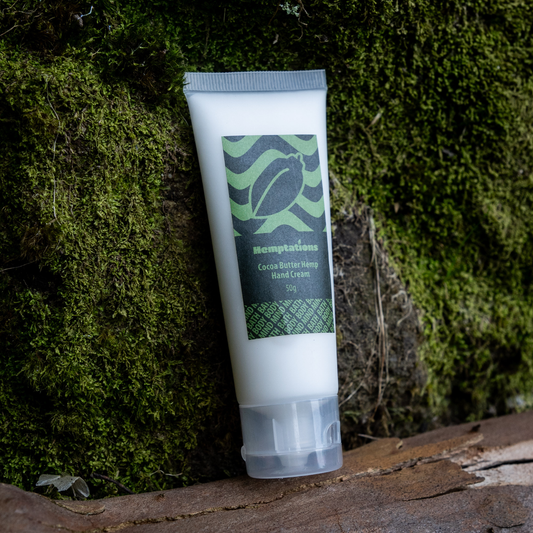 Tube of cream on a wooden surface with a green leafy background