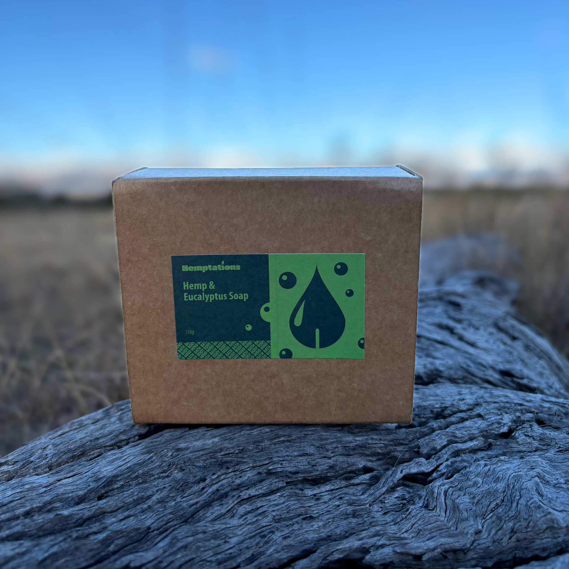 Box of Hemp & Eucalyptus Soap on a wooden log with a blurred natural background