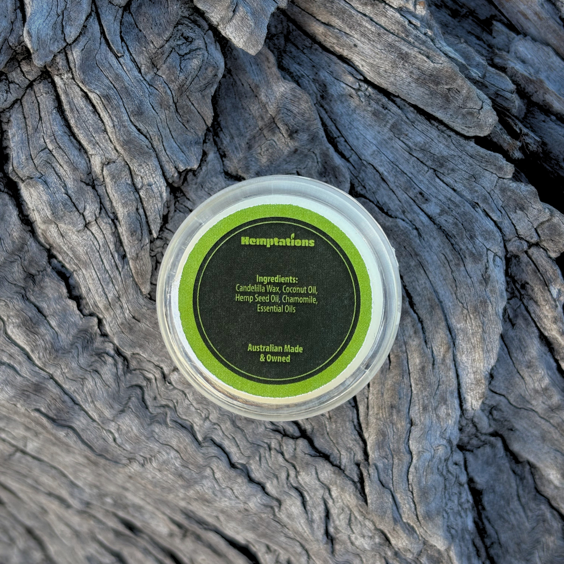 lip balm Container with a green label on a textured stone surface